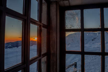 sunset seen through window with chipped glassの写真素材