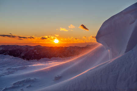 snow blizzard high in the mountains at sunset