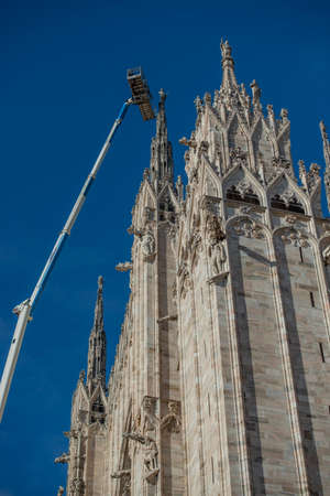 Milan Italy 1 December 2021: Technicians on lifting platform for scheduled maintenance plan and study of the degradation phenomena of the Milan cathedralの写真素材