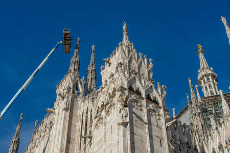 Milan Italy 1 December 2021: Technicians on lifting platform for scheduled maintenance plan and study of the degradation phenomena of the Milan cathedralの写真素材
