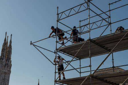 Milan Italy 29 June 2022: Workers who are assembling the stage structure for a show in piazza duomo...