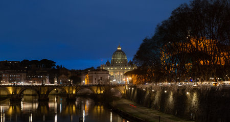 St. Peter's Basilica illuminated at night seen from the luno tiberの写真素材