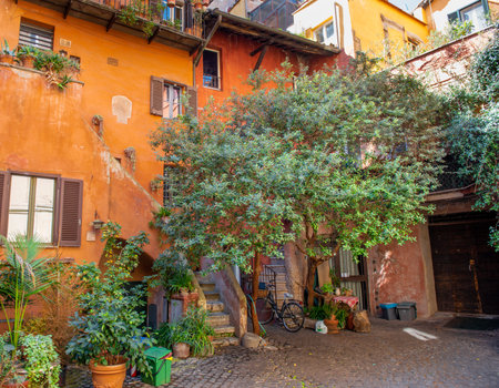 Small courtyard in Rome, with rustic ocher houses and vine trees.のeditorial素材