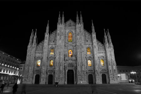 Milan Cathedral with illuminated stained glass windows at nightの写真素材