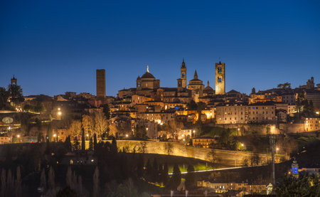 Skyline of old Bergamo at night with the bell towerの写真素材