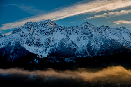 Fog enveloping the mountains at sunsetの写真素材