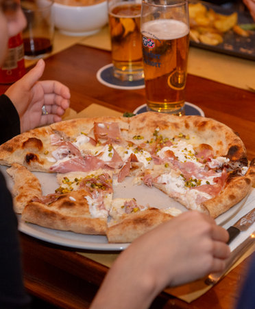 Bergamo Italy 21 December 2024: Group of friends eating pizzaの写真素材
