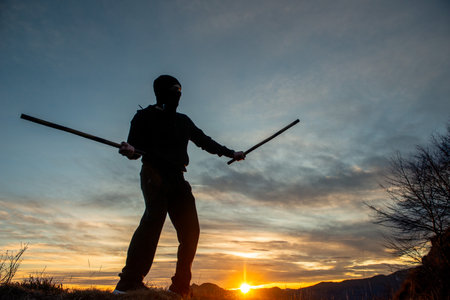 Training with poles at sunset on the top of the mountainの写真素材