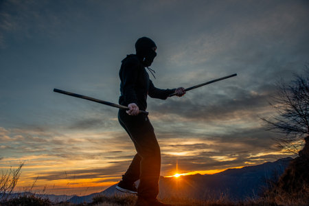 Training with poles at sunset on the top of the mountainの写真素材