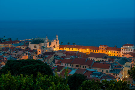 Pietra Ligure seen from above with the church of San NicolÃ² illuminated in the eveningの写真素材