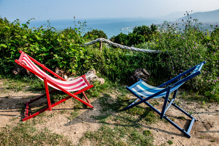 Two colored deckchairs to observe Loano in all its splendor from the hillの写真素材