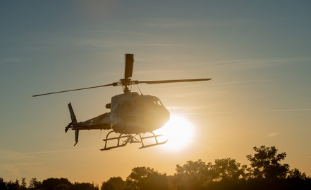 Helicopter flying with the sun as a background