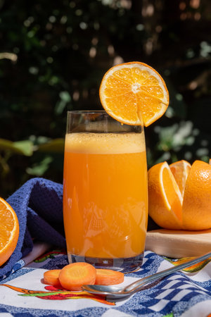 Glass of fresh orange juice with a slice of orange on a tableの写真素材