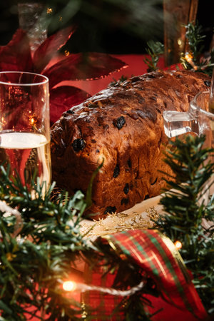 Christmas cake with raisins and glass of champagne on a red background, close-upの写真素材