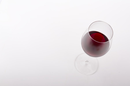 glass of red wine on a white background seen from aboveの写真素材