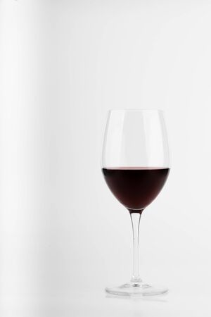 glass of red wine still seen from the front of a white backgroundの写真素材
