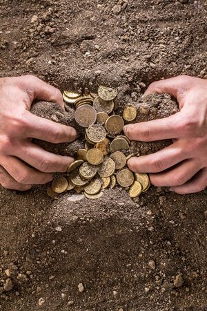 man's hands in the land with moneyの写真素材