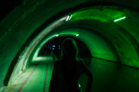 silhouette of girl in green tunnelの写真素材