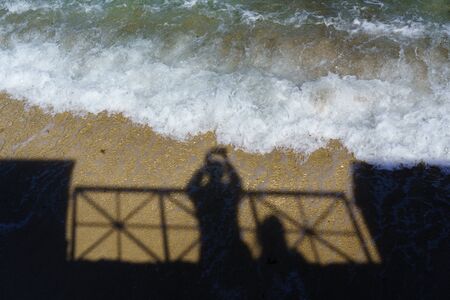 shadow of man photographing coastの写真素材