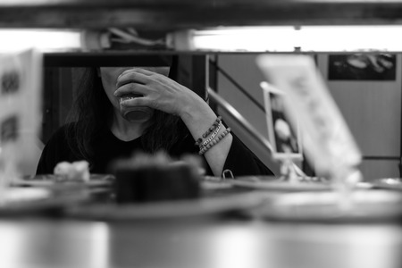 woman in Sushi restaurant drinking green teaの写真素材