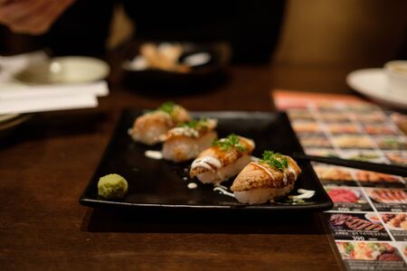 Sushi in restaurant with grilled salmonの写真素材