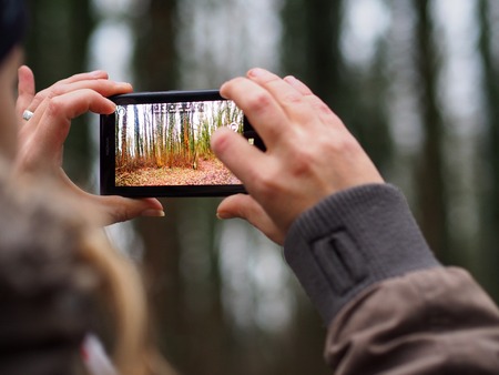 girl photographing forest