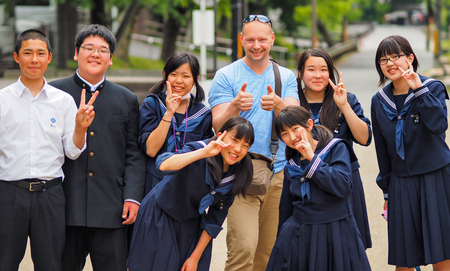 Nara, Japan - May 14: Photographer Pierre Aden poses with Japanese students for a photo on May 14, 2014 in Naha, Japanのeditorial素材