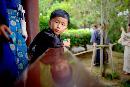 Naha, Japan - November 19: Young boy in traditional clothes in park looks at camera on November 19, 2015 in Naha, Japan.のeditorial素材