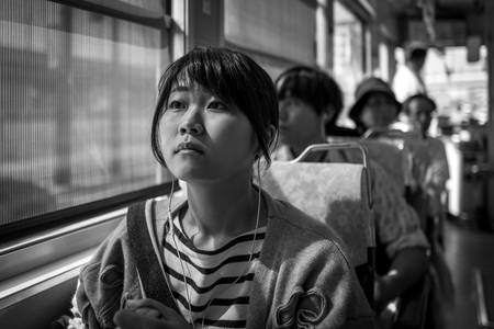 Kumamoto, Japan - May 13: Young girls sits in tram on May 13, 2017 in Kumamoto, Japan.のeditorial素材