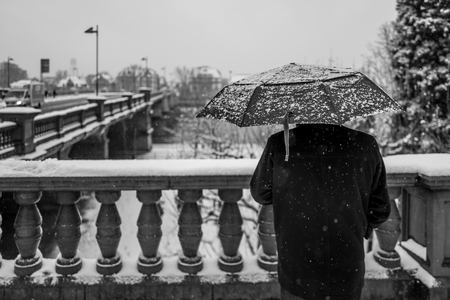 Rear view of man with umbrella in snowy Frankfurtの写真素材