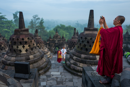 Yogyakarta, Indonesia - March 17, 2018: Monk makes photos at Borobudur temple sunrise in Yogyakartaのeditorial素材