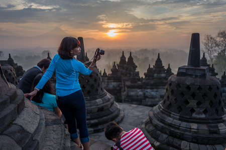 Yogyakarta, Indonesia - March 17, 2018: Asian woman makes photos at Borobudur temple sunrise tourのeditorial素材