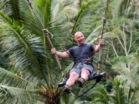 caucasion man having fun at Bali swing