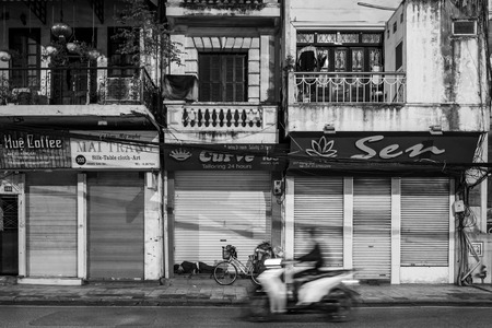 Hanoi, Vietnam - april 14, 2018: Scooter drives in front of sleeping man on the streets of Hanoi.のeditorial素材