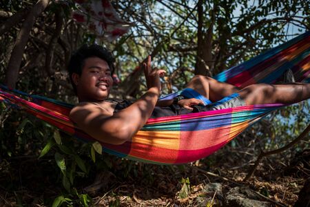 Ko Adang, Thailand - February 19, 2019: Local man in hammock smiling at camera.のeditorial素材