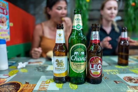 Koh Lipe, Thainald - February 20, 2019: Thai beers with caucasian girls in background.のeditorial素材