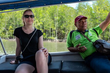 Langkawi, Malaysia - February 23, 2019: Local Ranger and caucasian girl at Mangroves tour in Kilim...