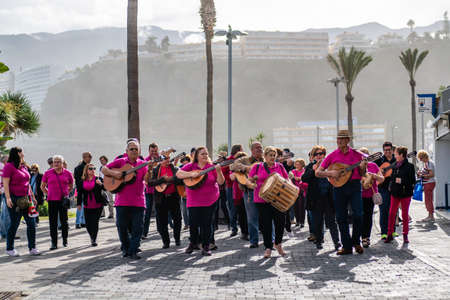 Tenerife, Spain - December 15, 2019: A group of musicians walking a street and making music on the...
