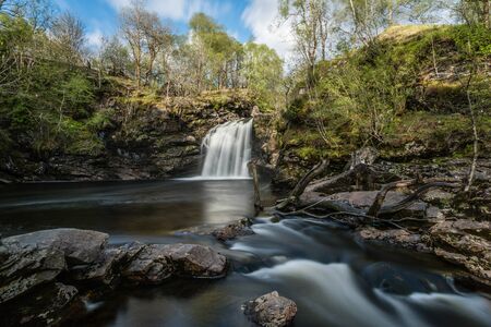 Dreamy waterfall and river in woodlands