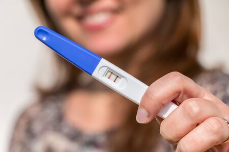 woman holding a positive pregnancy testの写真素材