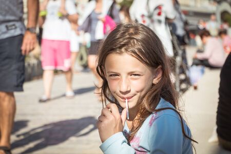 Sables-d-Olones, France - July 05, 2016 : a little girl eats a lollipop on the beachのeditorial素材