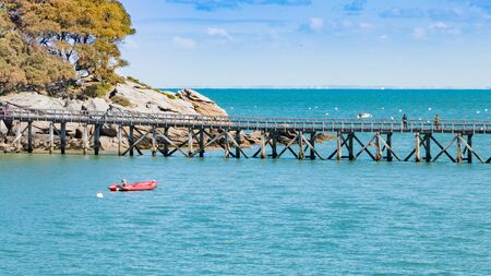 Noirmoutier, France - April 28, 2016 : wooden bridge on the sea with a boatのeditorial素材