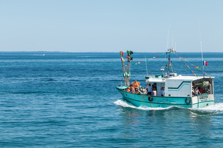 Noirmoutier, France - August 15, 2016 : Day of the Sea - a sea trawler hand to throw bouquets of flowersのeditorial素材