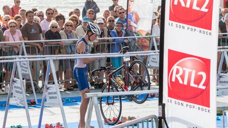 Saint Gilles Croix de Vie, France - September 10, 2016 : Final triathlon championship of France in the category D3 - after exiting the water, athletes take their racing bikeのeditorial素材