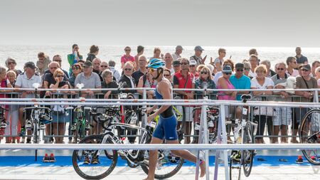 Saint Gilles Croix de Vie, France - September 10, 2016 : Final triathlon championship of France in the category D3 - after exiting the water, athletes take their racing bikeのeditorial素材