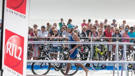 Saint Gilles Croix de Vie, France - September 10, 2016 : Final triathlon championship of France in the category D3 - after exiting the water, athletes take their racing bikeのeditorial素材