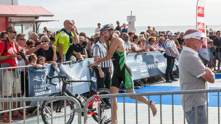 Saint Gilles Croix de Vie, France - September 10, 2016 : Final triathlon championship of France in the category D3 - athlete running with his bike to the bike courseのeditorial素材