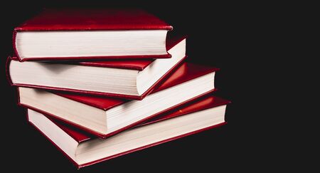 Old red encyclopedias bound leather on black backgroundの写真素材
