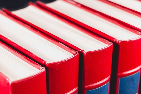 Old red encyclopedias bound leather on black backgroundの写真素材