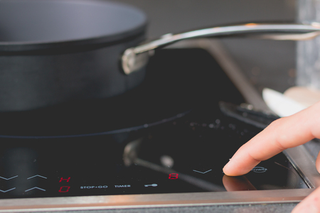 Cook who starts Induction Cooktops in a kitchenの写真素材